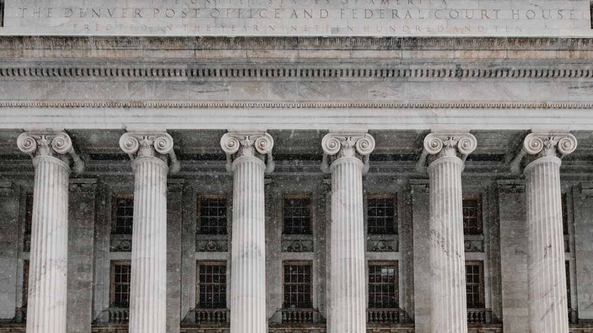 The colonnade of the Denver Post Office and Federal Court House, with an inscribed stone frieze above marble Ionic columns